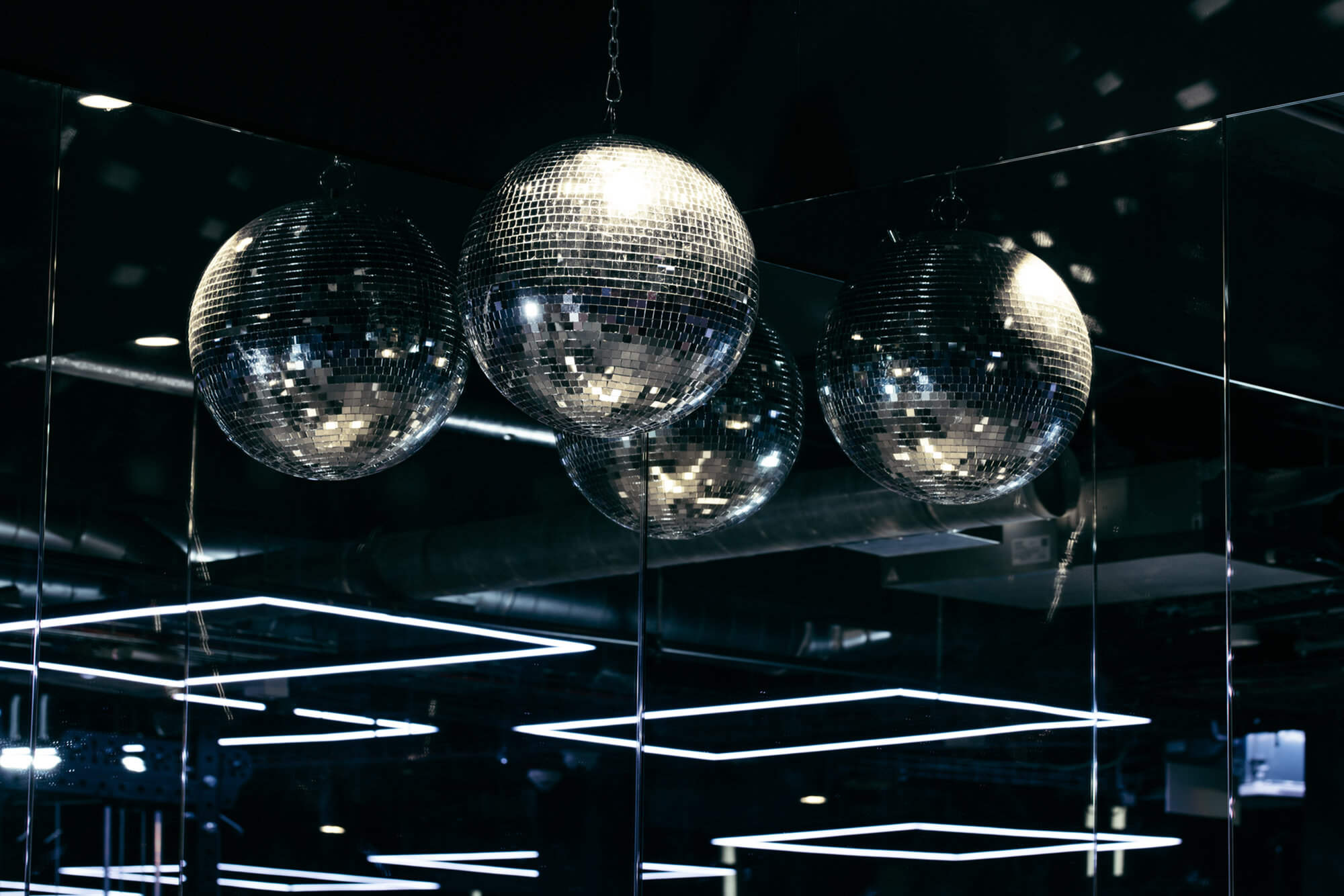 Silver disco balls above The Ministry gym, reflected in mirrors